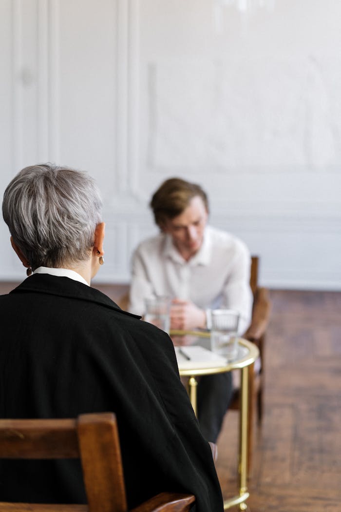 A therapist conducting a counseling session with a patient in a serene office setting.
