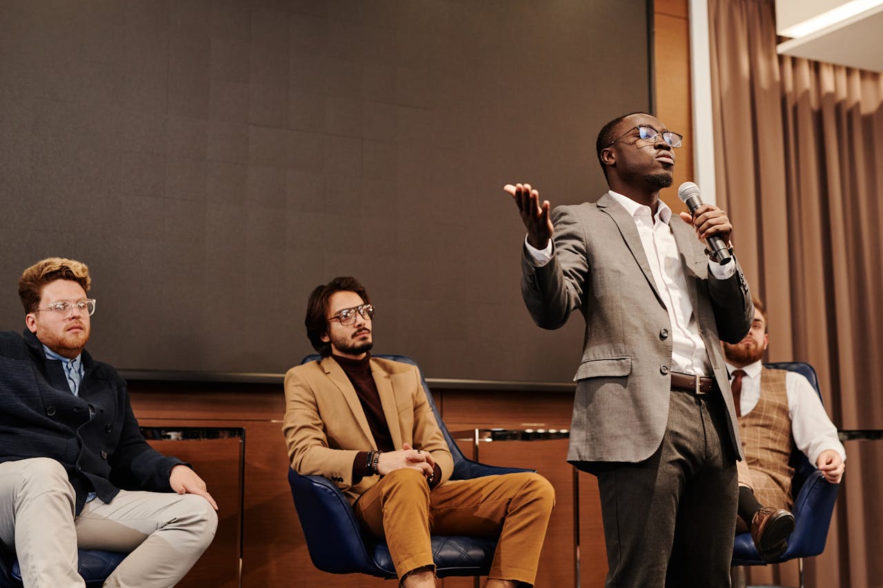 Crafting Captivating Headlines: Your awesome post title goes here A diverse group of professionals engaged in a business panel discussion with a speaker presenting.